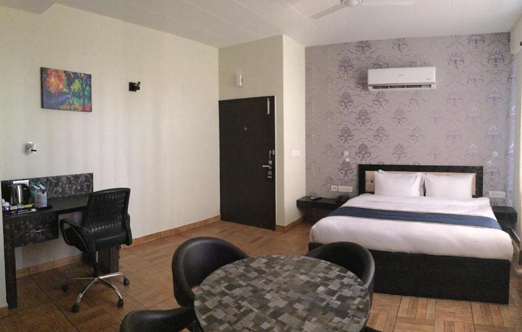 a hotel room with a bed and a table and chairs at The Park Residency in Greater Noida