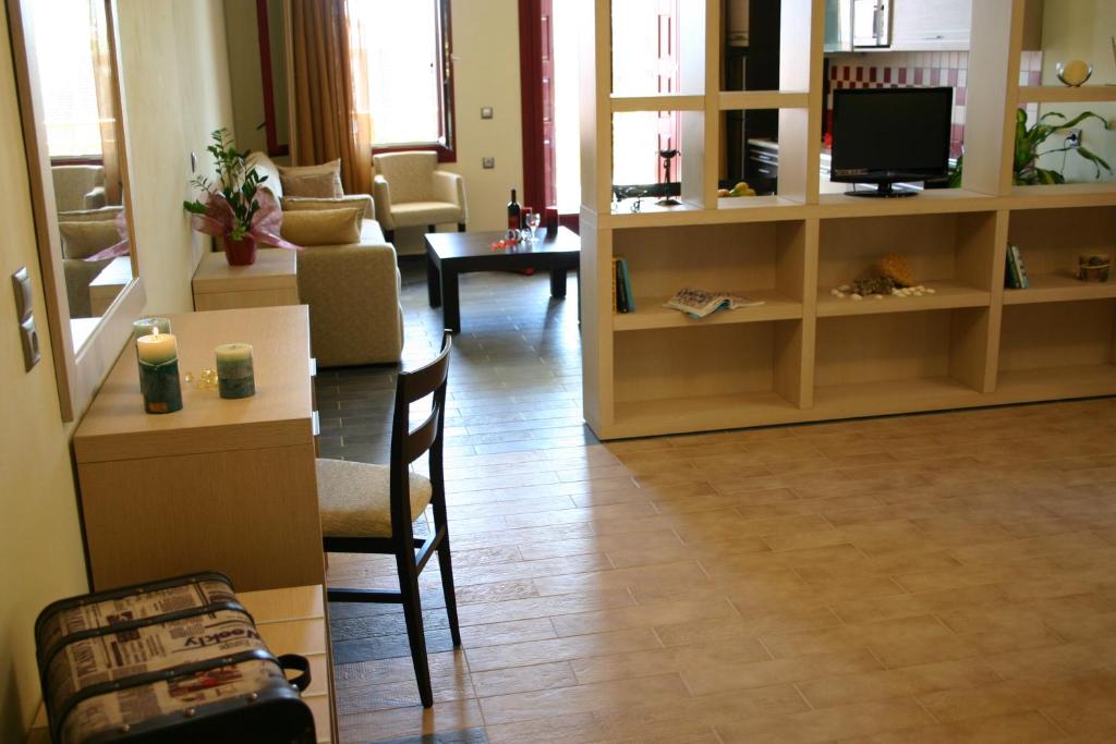 a living room with a television and a table and chairs at Sirena Residence & Spa in Marathokampos
