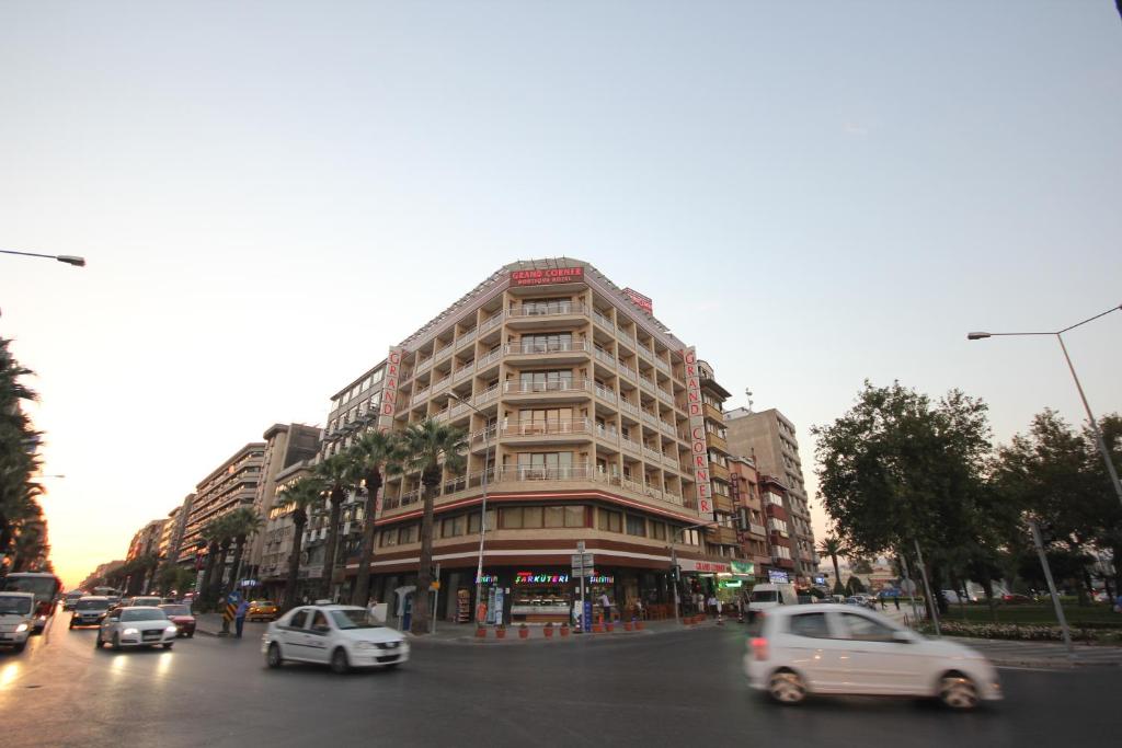 un edificio alto en una calle de la ciudad con coches en Grand Corner Boutique Hotel en İzmir