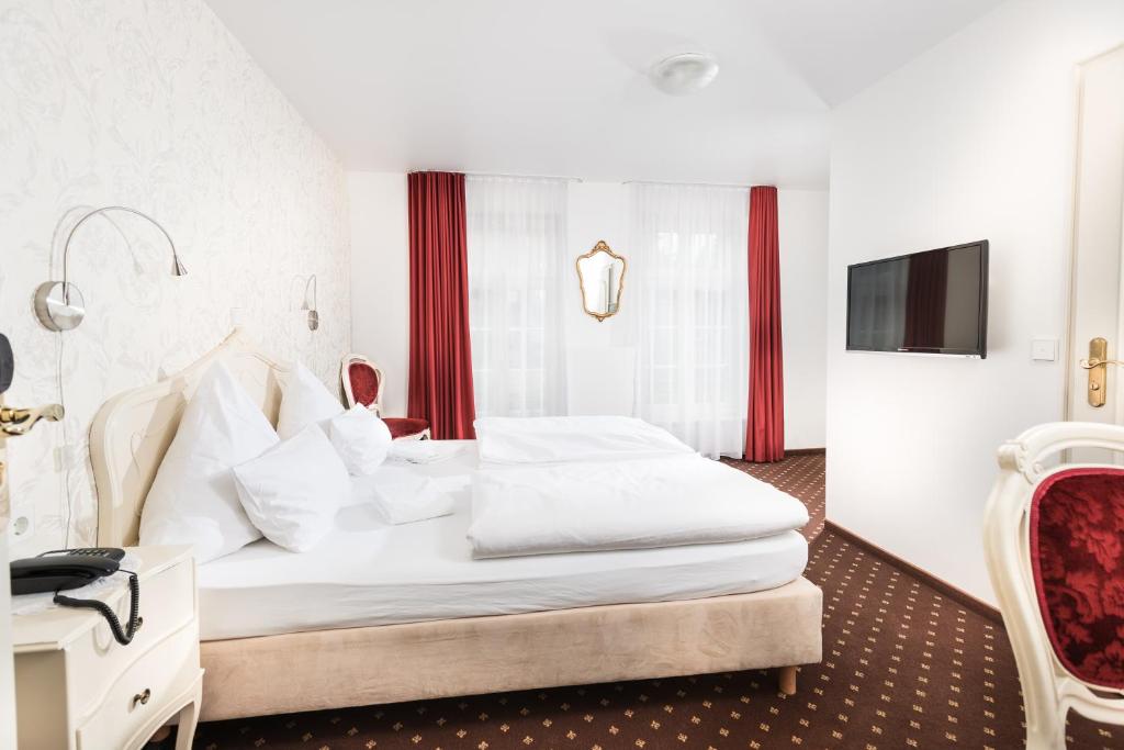 シュヴェービッシュ・グミュントにあるHotel Einhornのベッドとテレビ付きのホテルルーム