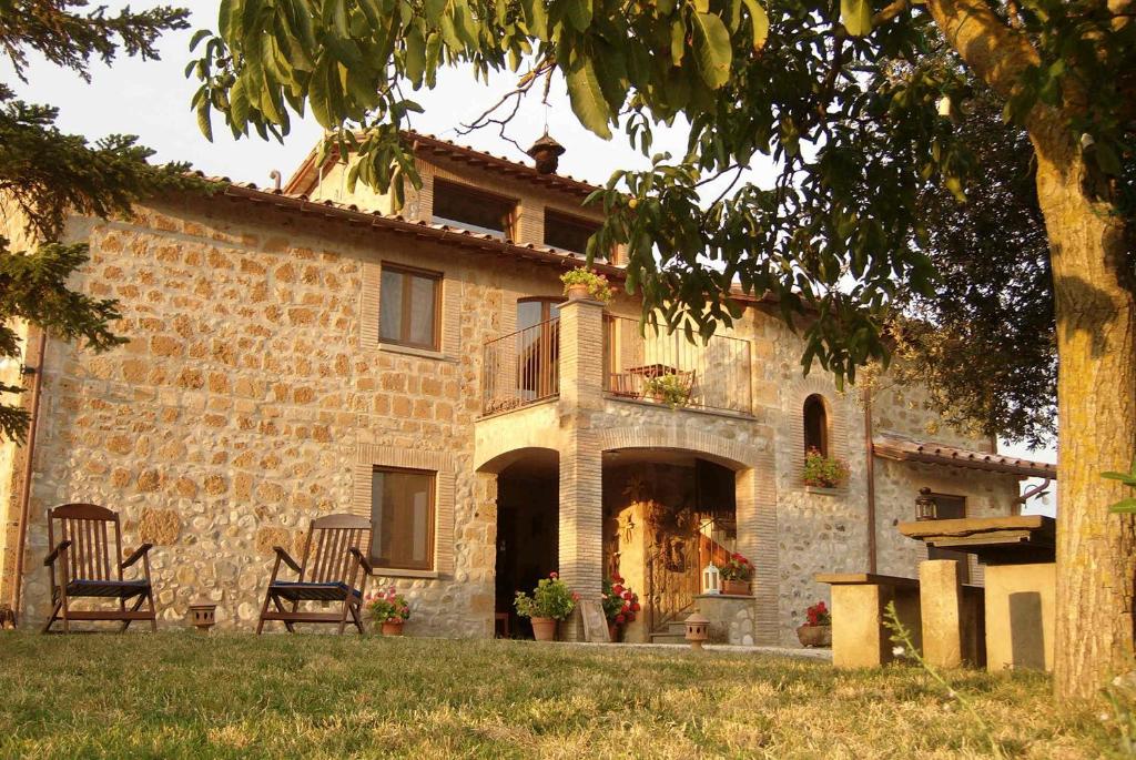 a stone house with two chairs in front of it at Agriturismo Cioccoleta in Orvieto