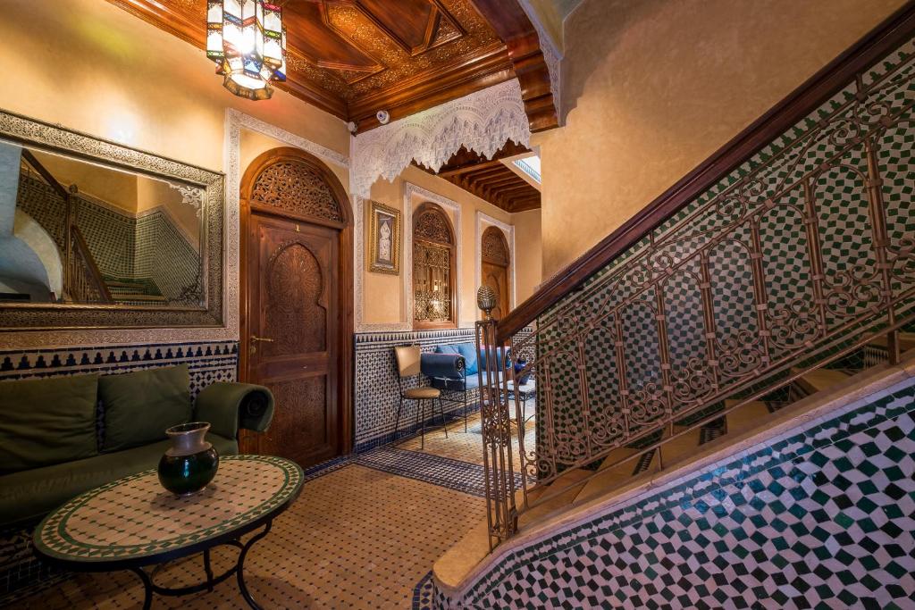 sala de estar con mesa y escalera en Riad Saad en Marrakech