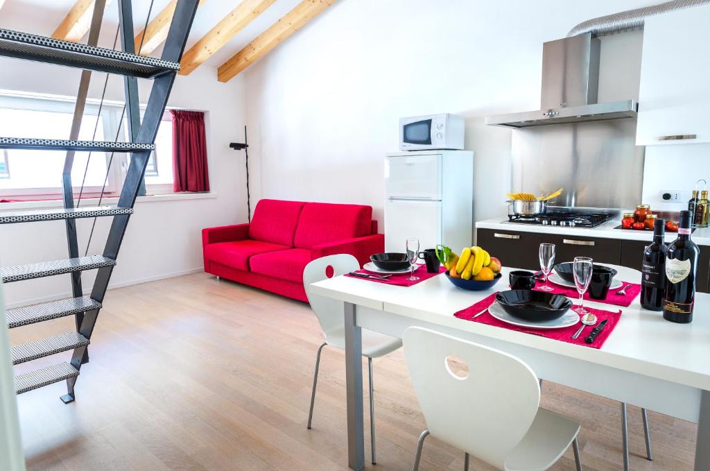 cocina y sala de estar con sofá rojo en Appartamenti Segantini, en Arco