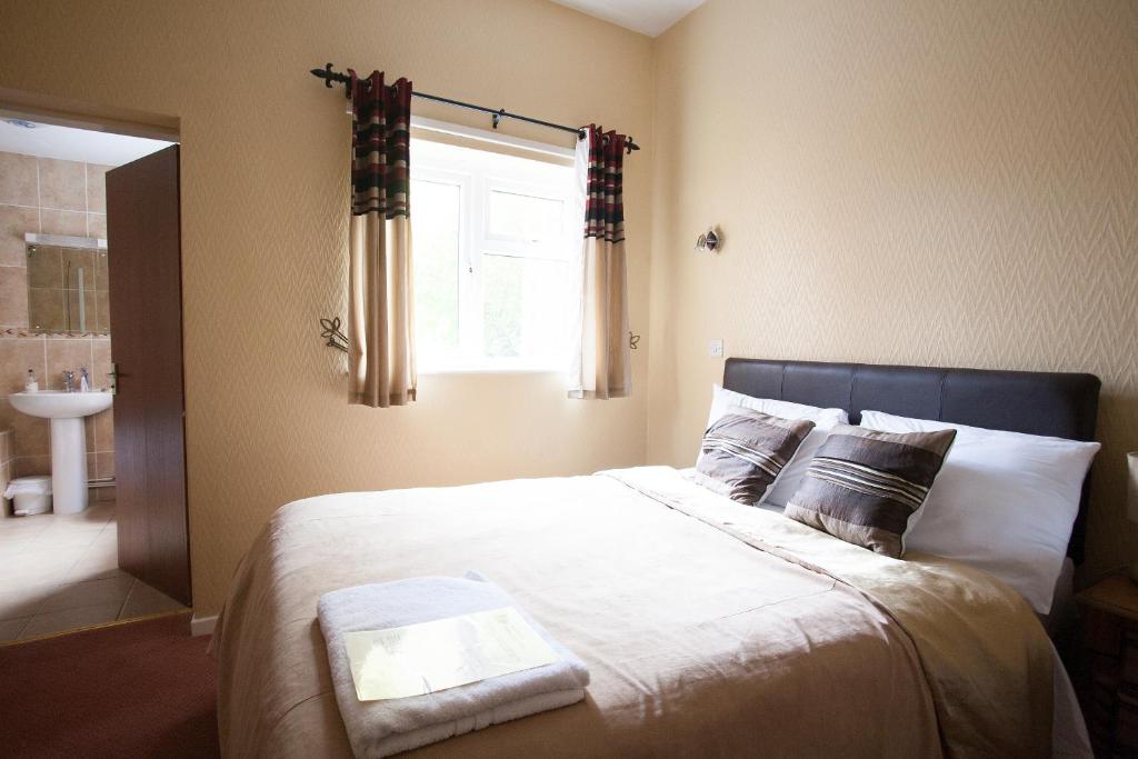 a bedroom with a large bed with a window at Barons Court Hotel in Wolverhampton