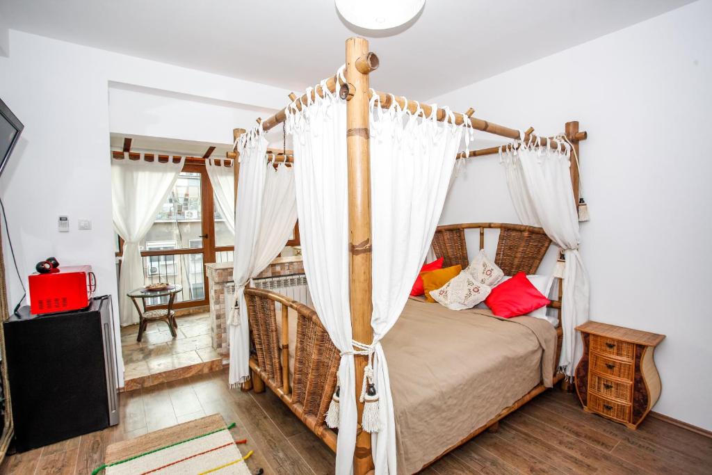 1 dormitorio con cama con dosel y cortinas blancas en City Center Oasis, en Bucarest