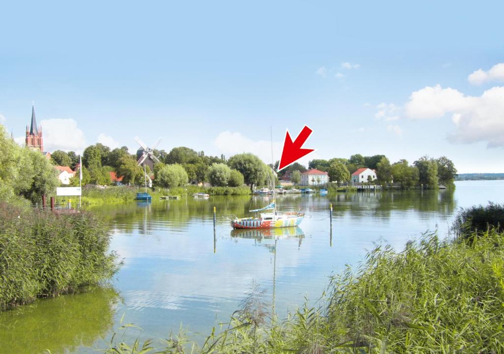 un barco en un río con una flecha roja en Am Inselufer, en Werder
