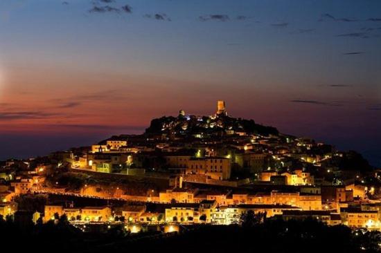 una ciudad en la cima de una colina por la noche en Sa Domo Antiga en Osilo