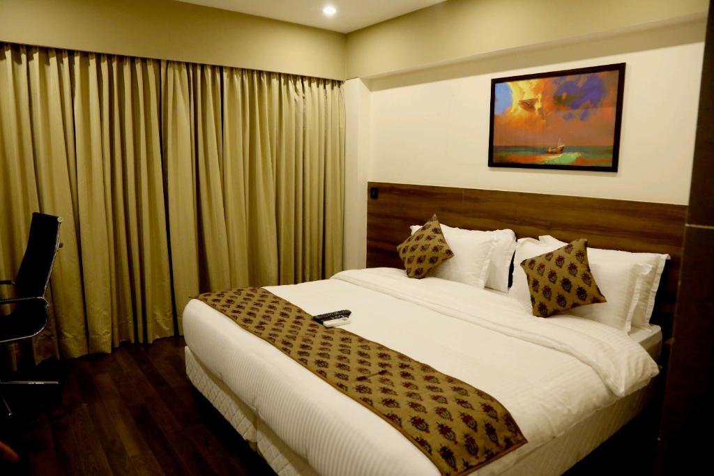 una habitación de hotel con una cama grande en una habitación en Hotel Mumbai House Andheri East, Mumbai en Bombay
