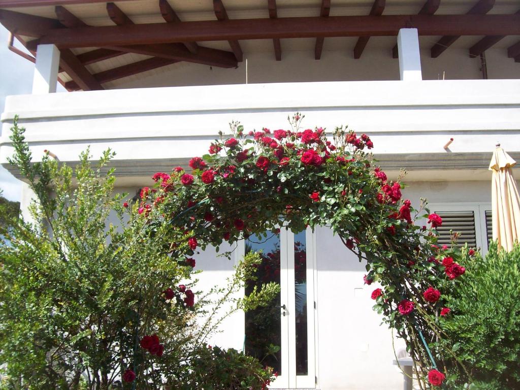 una corona de rosas rojas en una casa blanca en B&B Kazakova, en Domusnovas