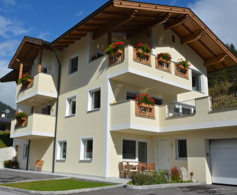 a building with potted plants on the balconies at Alexandra's Apartment in Neustift im Stubaital