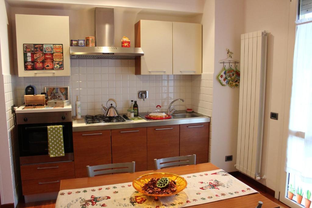 La casa di Federica, at home في بيروجيا: مطبخ مع دواليب خشبية وطاولة عليها صحن