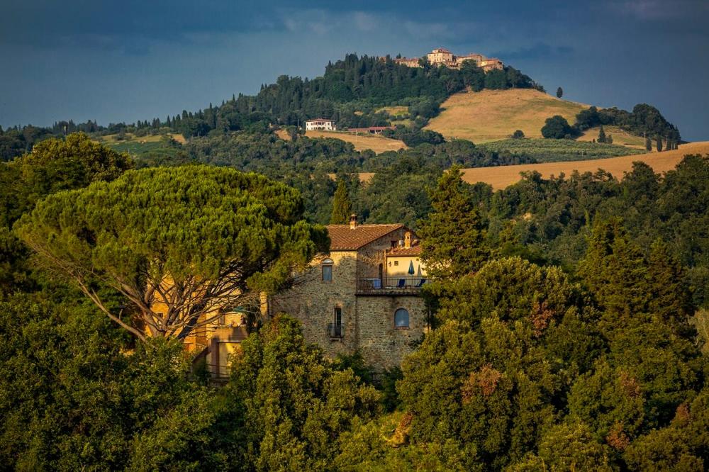 una vieja casa en una colina en el bosque en Agriturismo Alle Rose, en Volterra