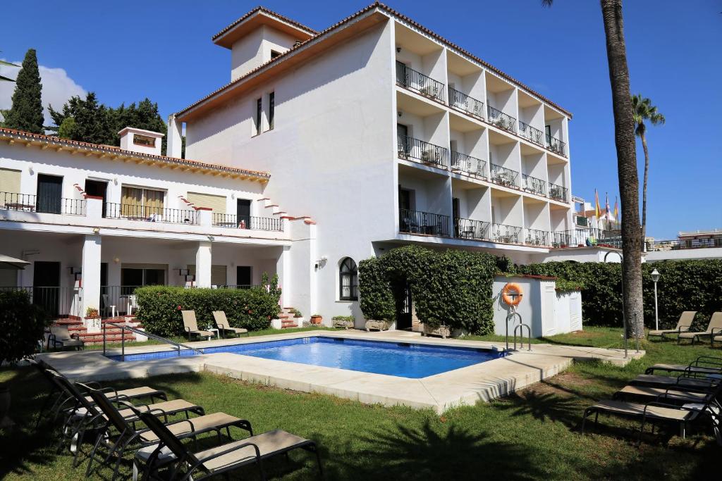 a large white house with a pool and trees at Arcos de Montemar in Torremolinos