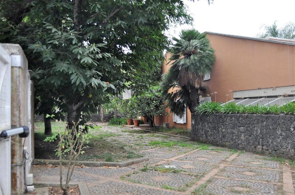 a garden with trees and a wall and a building at Casita en Guamasa in Tacoronte