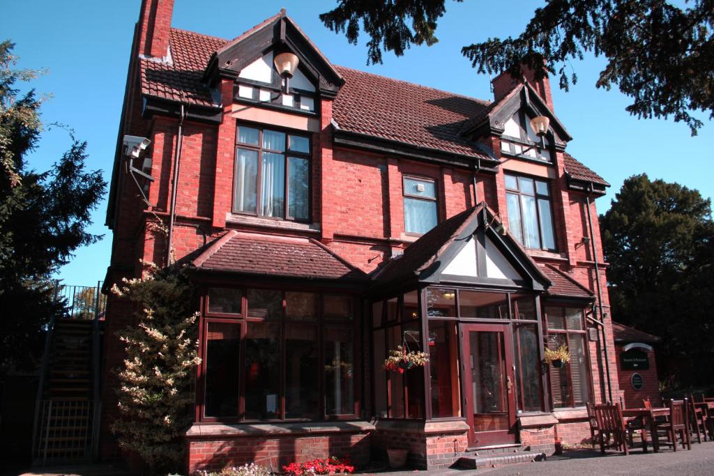 una casa de ladrillo rojo con techo negro en Blaby Westfield Hotel, en Leicester