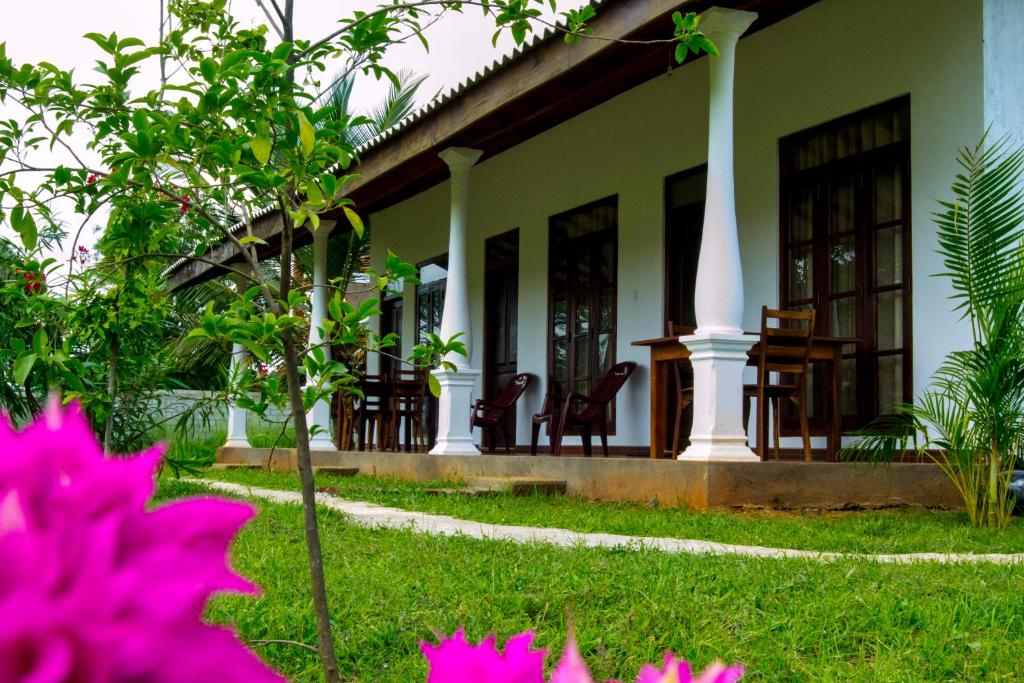 dom z krzesłami i kwiatami na dziedzińcu w obiekcie Nature Lodge w mieście Sigirija