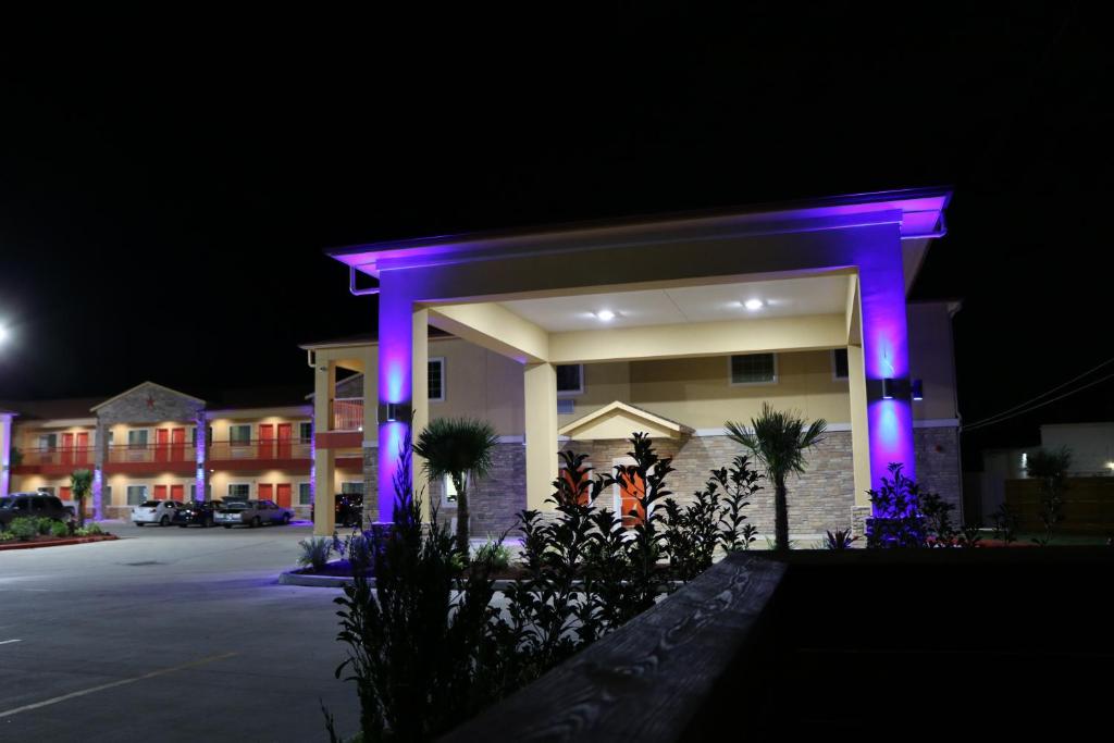 a building with purple lights in a parking lot at Scottish Inn & Suites - IAH Airport in Humble