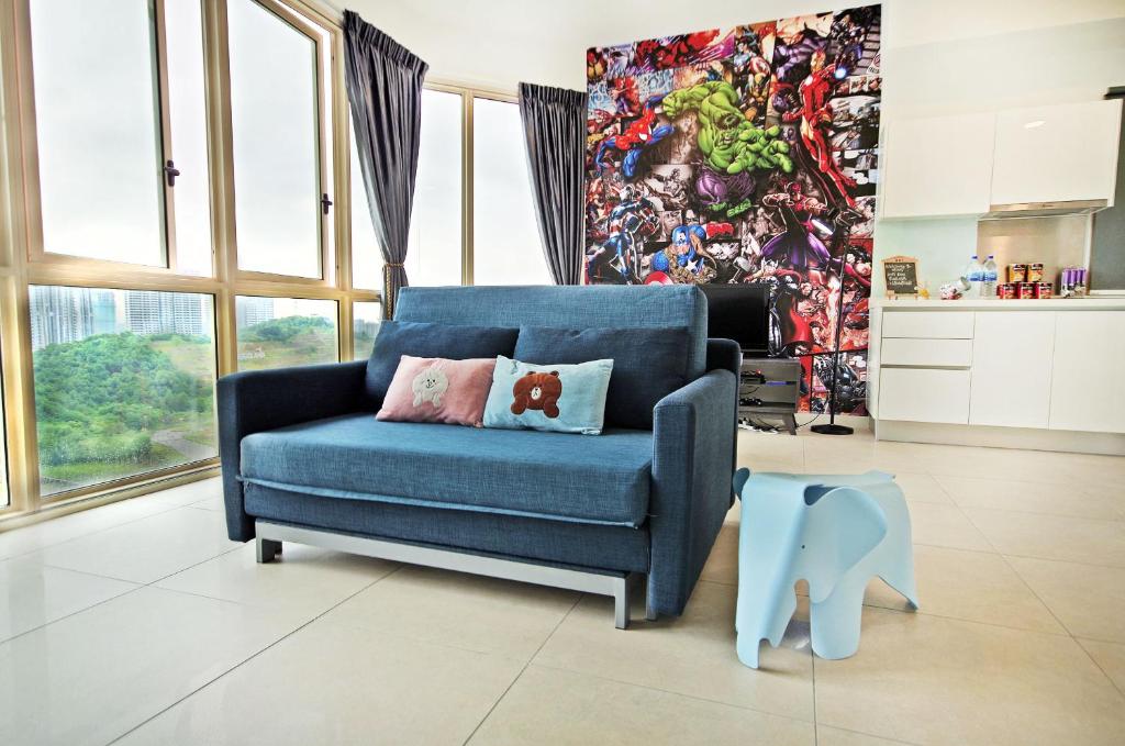 a blue chair in a living room with a mural at Afiniti Residences in Johor Bahru