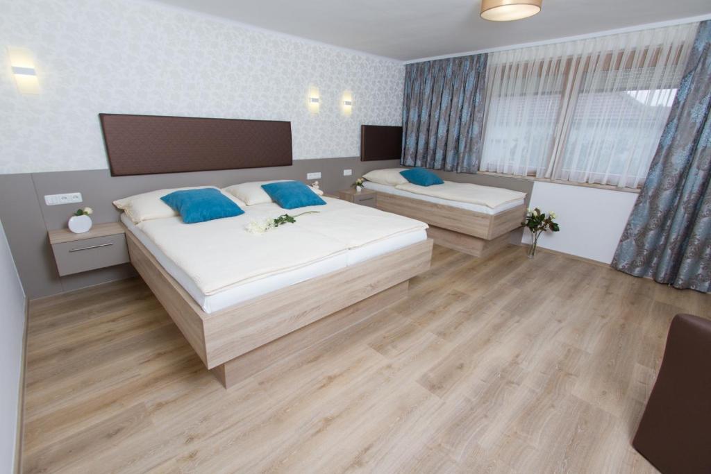 1 Schlafzimmer mit 2 Betten und einem großen Fenster in der Unterkunft Appartments Gartenblick in Illmitz