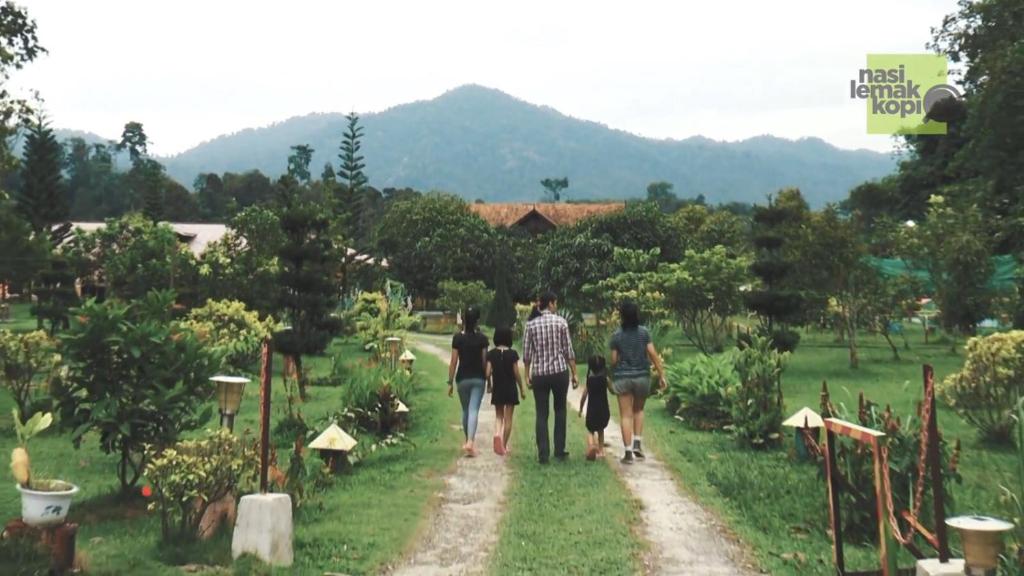 a group of people walking down a dirt road at Happy Paradise in Kampung Janda Baik