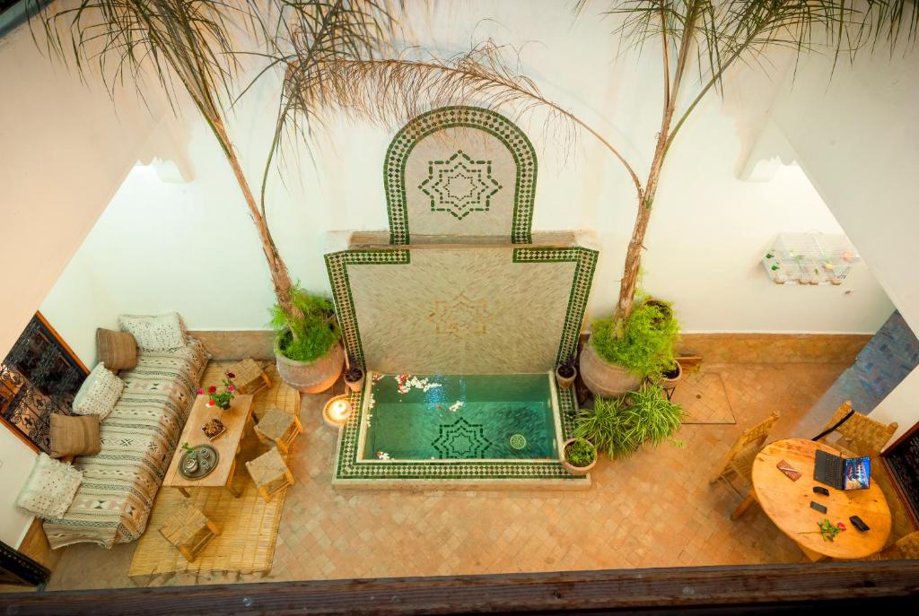 een woonkamer met een stoel en een zwembad bij Riad Dar Jdati in Marrakesh