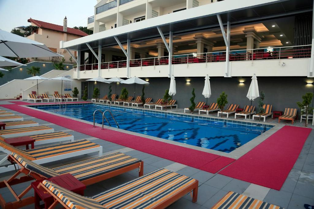 a swimming pool with lounge chairs and a hotel at Hotel Picasso in Vlorë