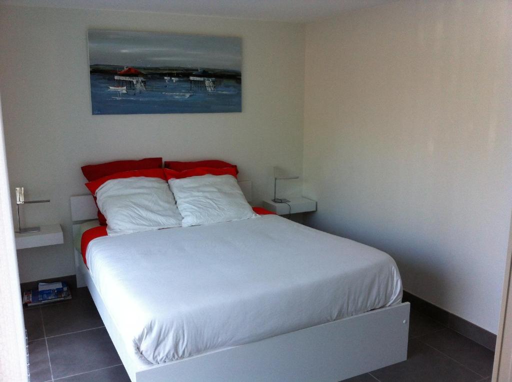 アルカションにあるEden Duneのベッドルーム1室(白いシーツと赤い枕のベッド1台付)
