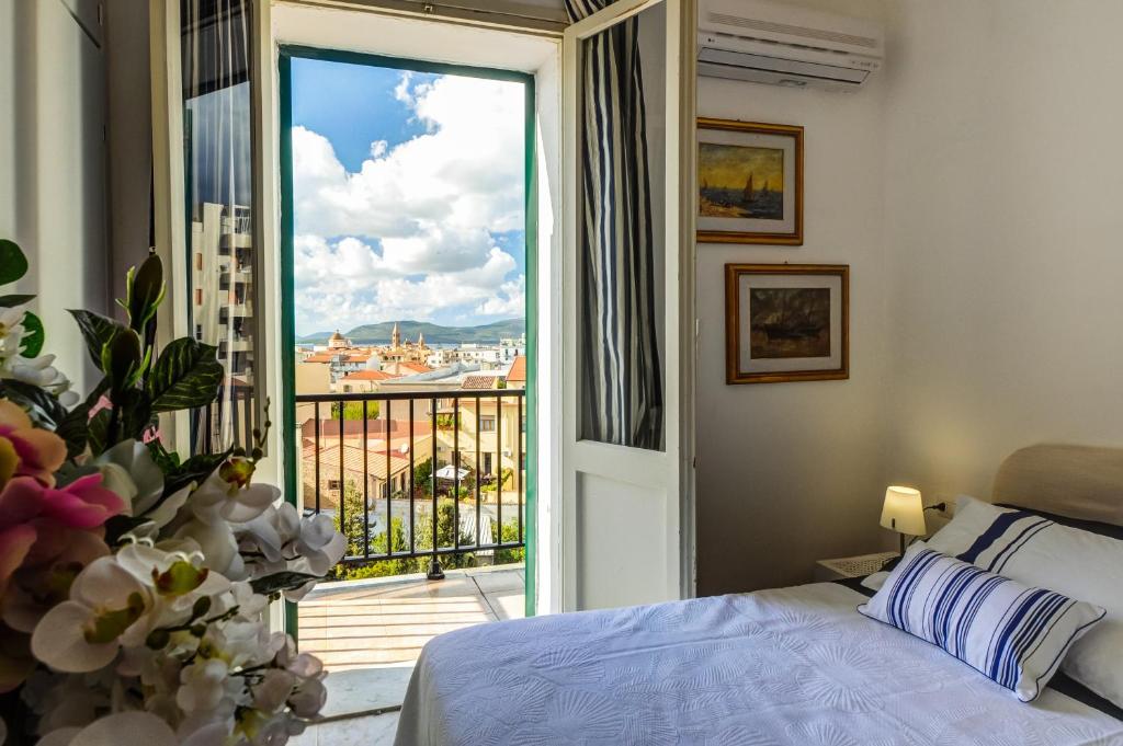 a bedroom with a bed and a balcony with a view at Alghero Roof Garden in Alghero