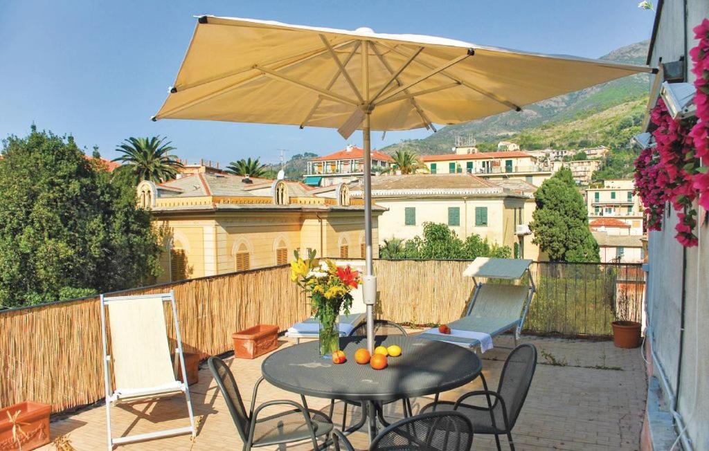 einen Tisch, Stühle und einen Regenschirm auf einer Terrasse in der Unterkunft Parmigiana in Levanto