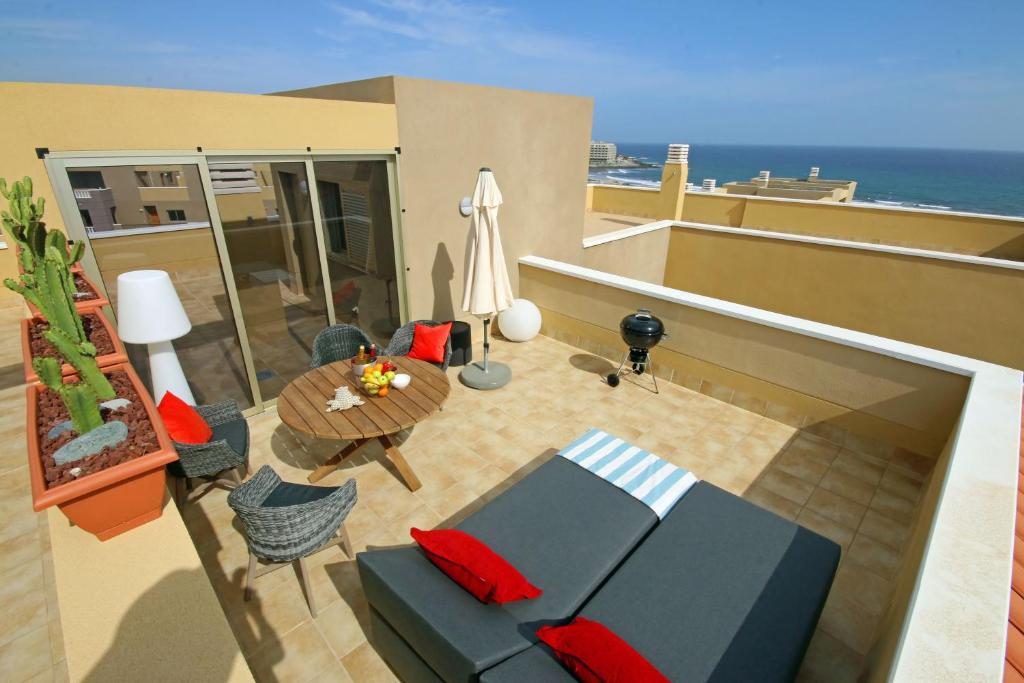 エル・メダノにあるLA PERLA by RENTMEDANO superb luxury duplex, private roof terrace, ocean view, pool, WiFi and parkingのリビングルーム(ソファ、テーブル付)