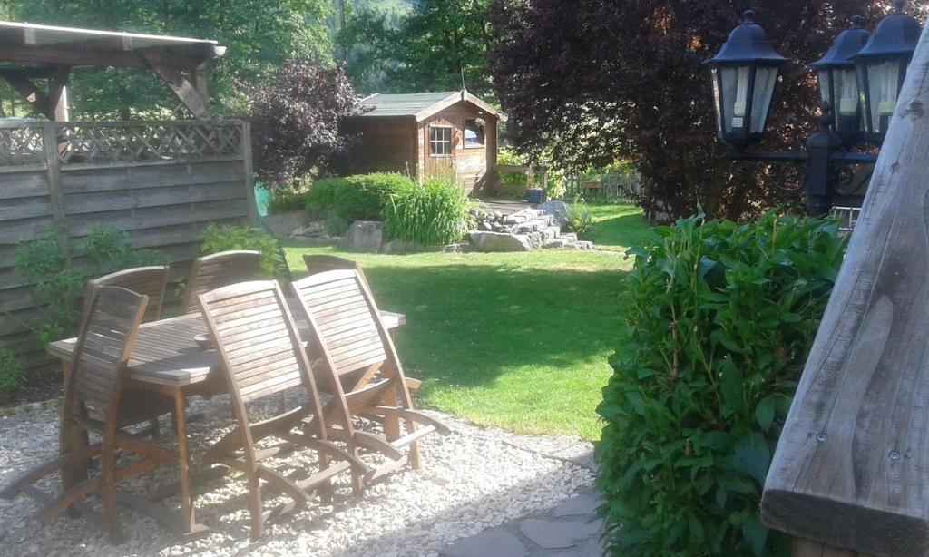 - une table et des chaises en bois dans le jardin dans l'établissement Evasion Nature, à Oberbruck