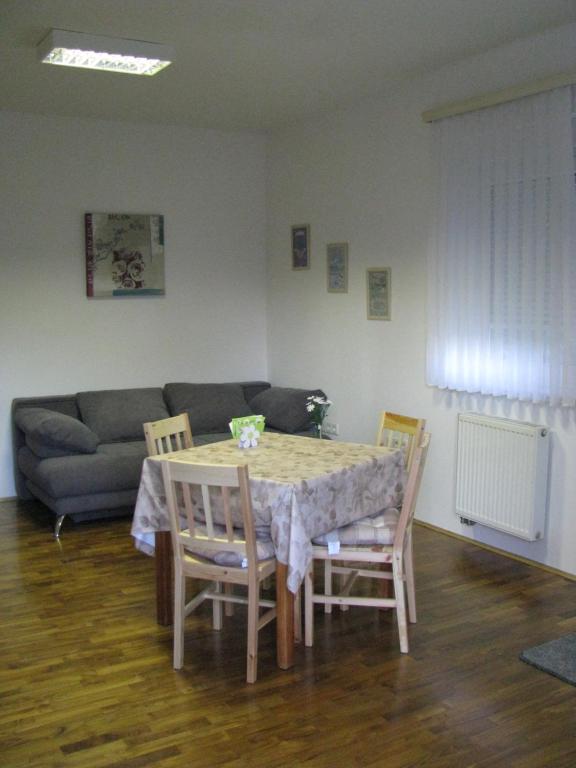 sala de estar con mesa, sillas y sofá en Hiša marjetica, en Maribor
