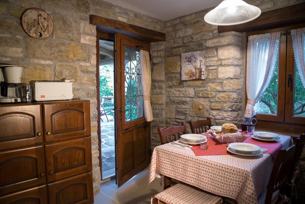jadalnia ze stołem i kamienną ścianą w obiekcie Holiday Home Casa Dei Farfui w mieście Momjan