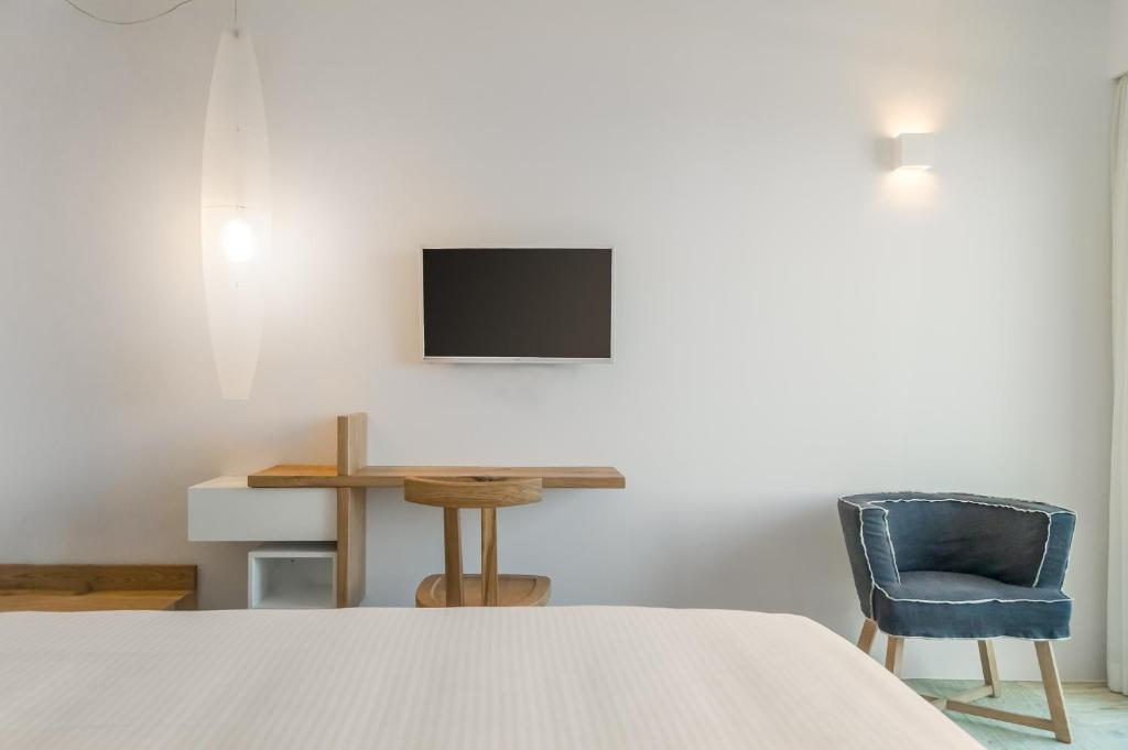 a bedroom with a bed and a desk and a tv at Semeli in Kokkari