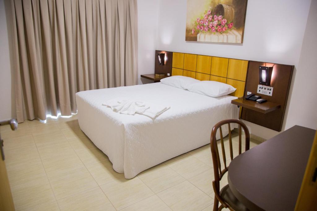 Postel nebo postele na pokoji v ubytování Dois Vizinhos Palace Hotel
