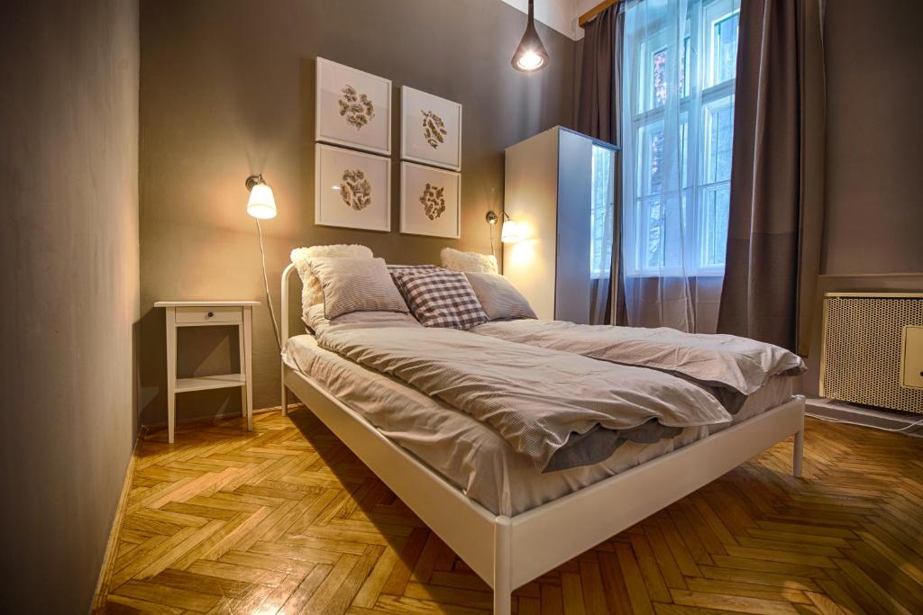 łóżko w pokoju z dużym oknem w obiekcie Logement Sous le Château w Budapeszcie