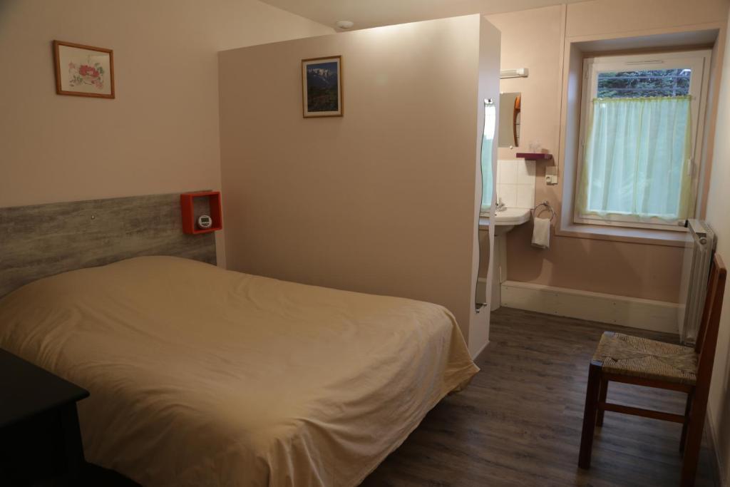 a bedroom with a bed and a sink and a window at Hotel Restaurant De La Roche in Les Sauvages