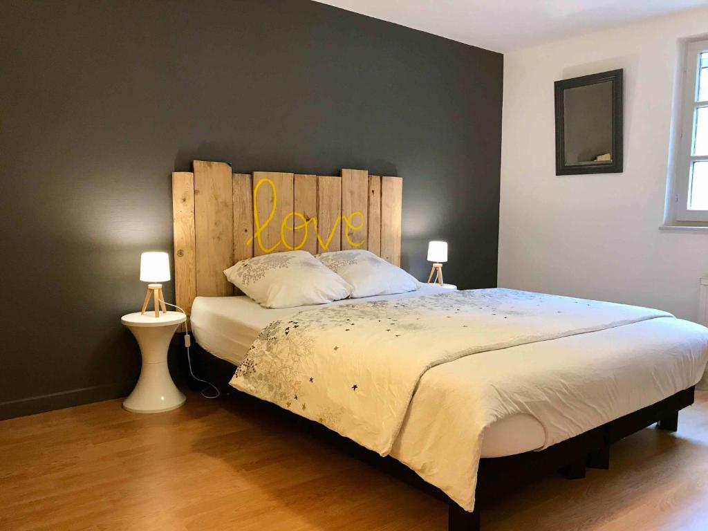 コルマールにあるMyAlsaceのベッドルーム1室(大型ベッド1台、木製ヘッドボード付)