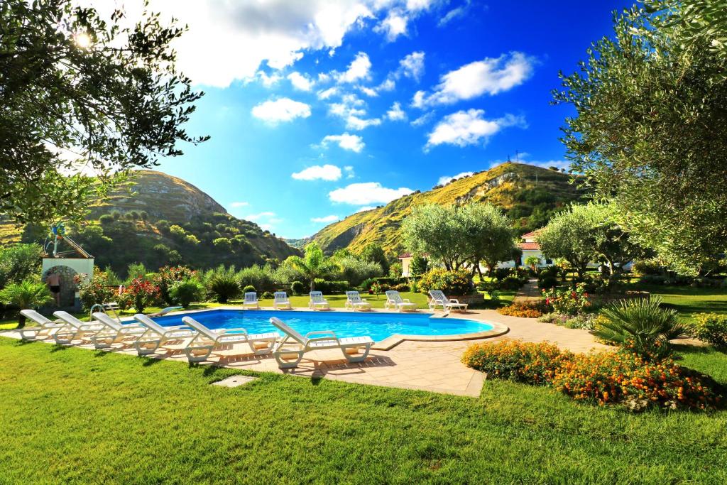 una piscina con tumbonas y montañas al fondo en Villa Garden, en Drapia