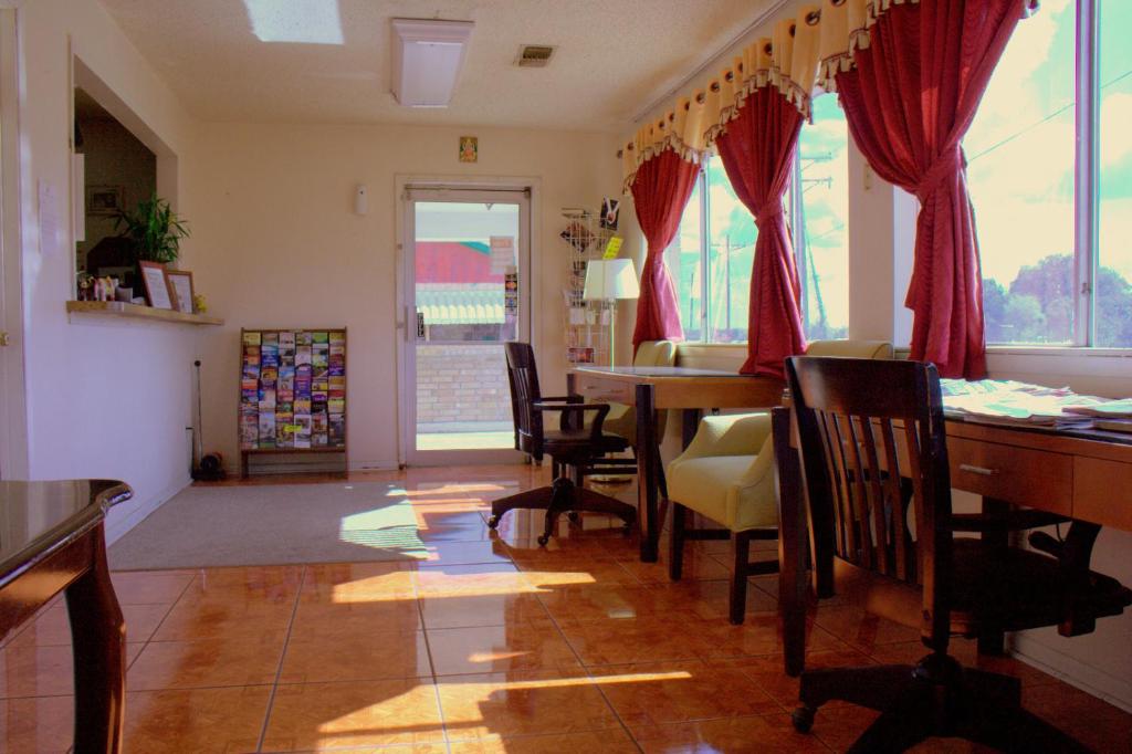 een woonkamer met een eettafel en stoelen bij Somerville Inn and Suites in Somerville