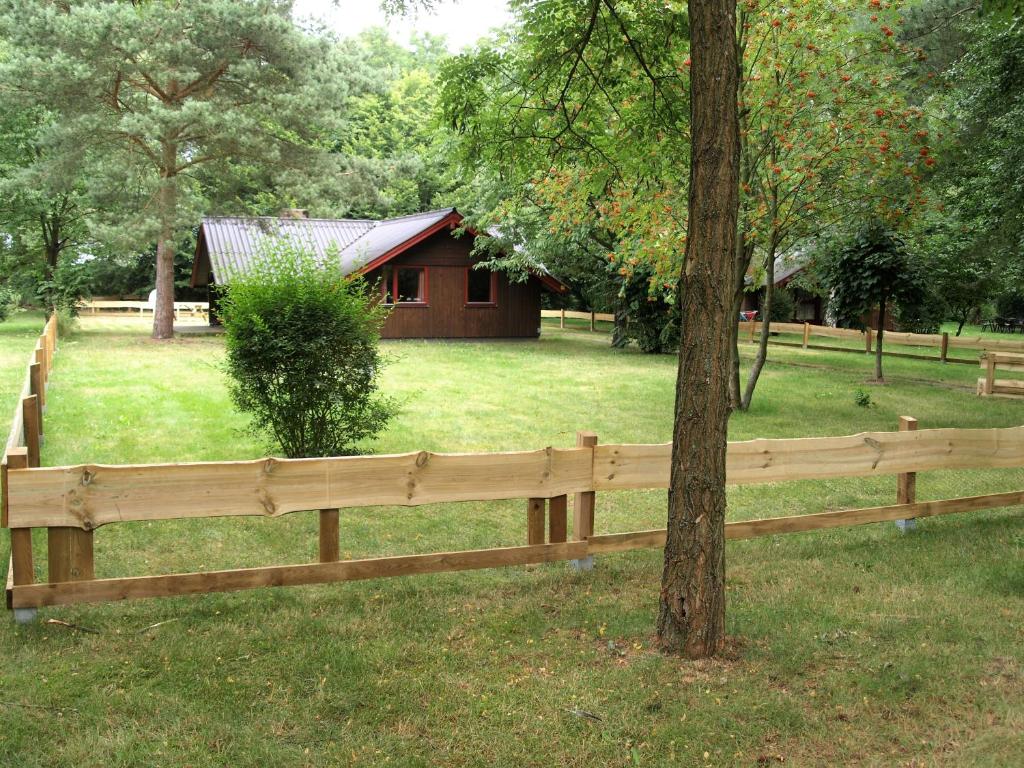 ein Holzzaun vor einem kleinen Haus in der Unterkunft Ferienhäuser Pannier I und oder II in Gartow