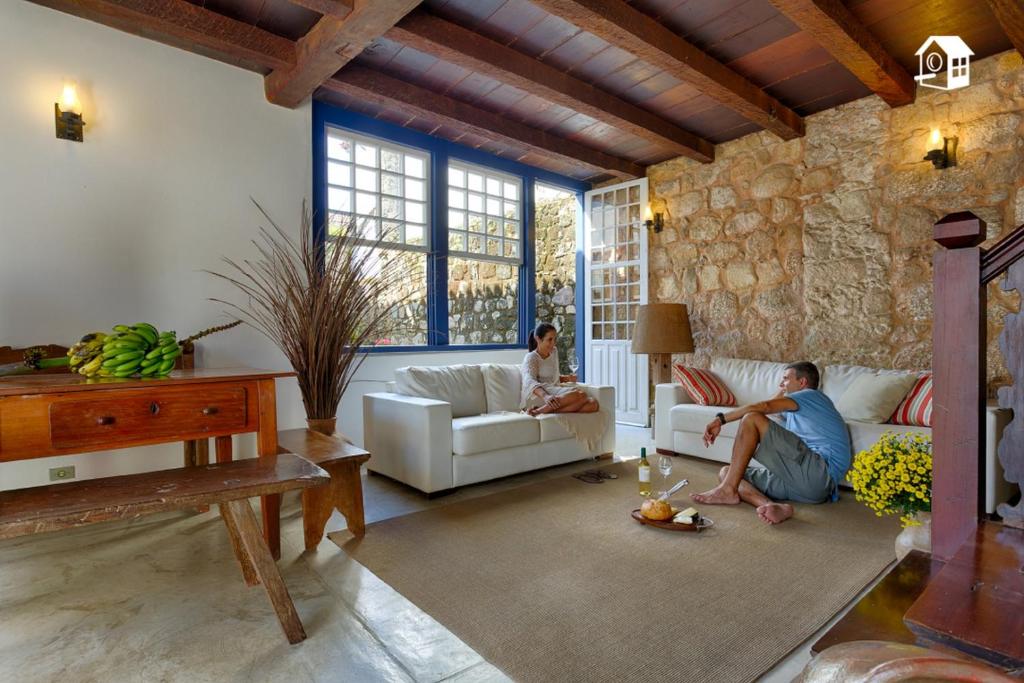 a man and a woman sitting in a living room at Casa no Centro Histórico com 3 Quartos in Paraty