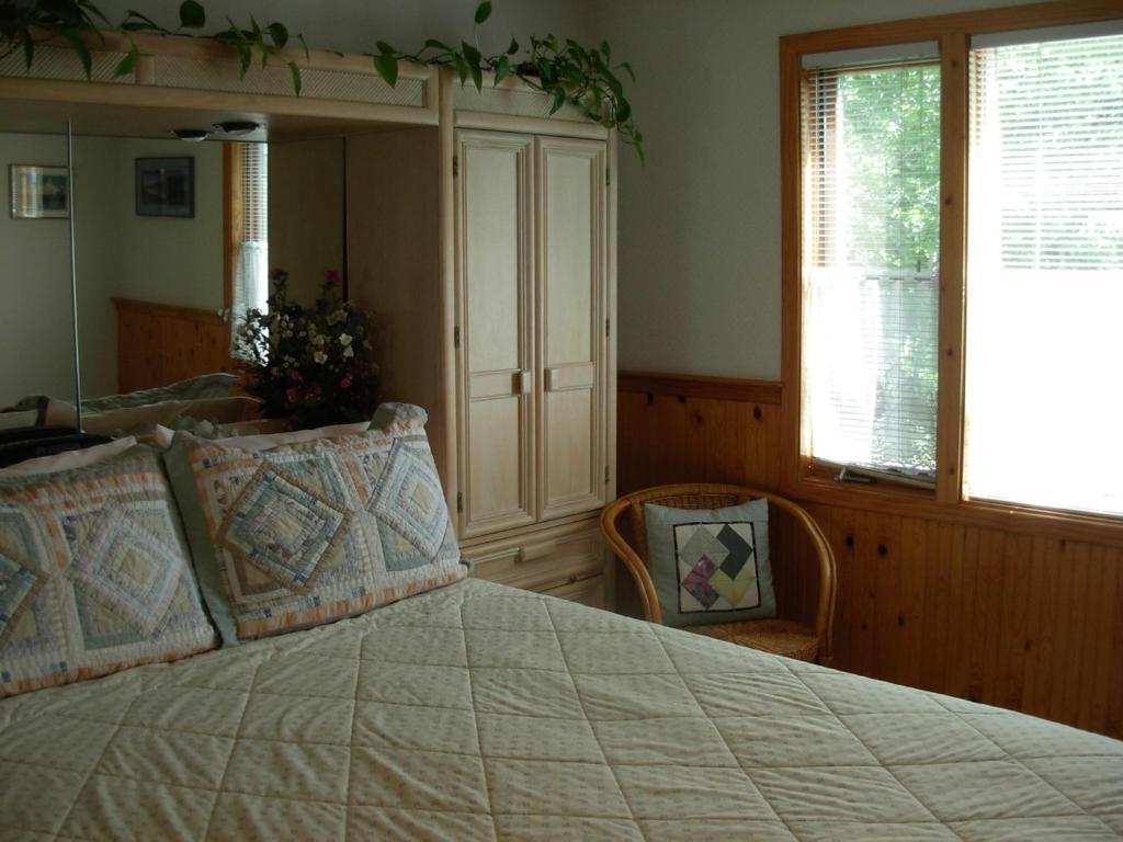 a bedroom with a large bed and two windows at Alaska Chalet Bed & Breakfast in Eagle River