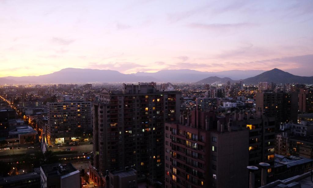 un perfil urbano por la noche con montañas en el fondo en Welcome to Santiago - Chile, en Santiago