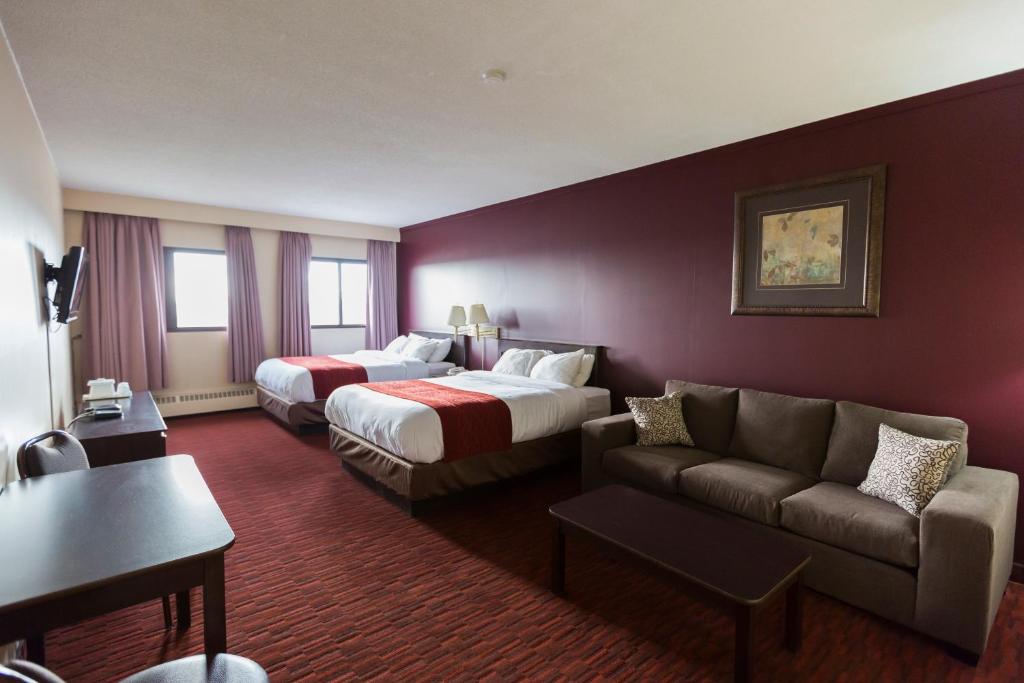 Argyll Plaza Hotel في إيدمونتون: غرفة فندقية بسريرين واريكة