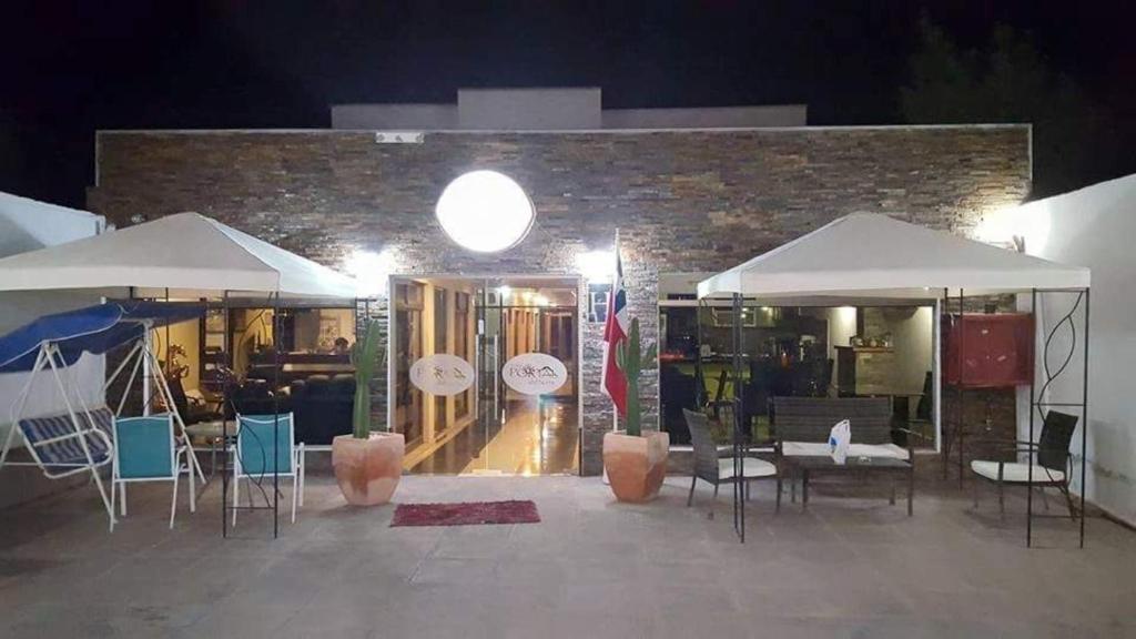 a restaurant with tables and chairs and white umbrellas at Hotel Portal del Norte in Copiapó