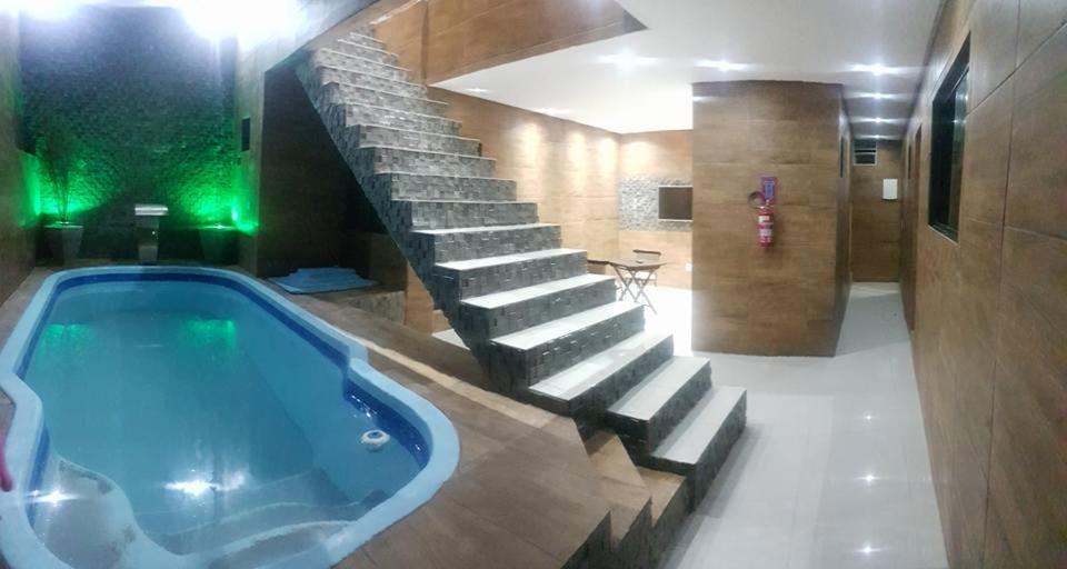 a bathroom with a jacuzzi tub and a staircase at Recanto Convenções in Olinda