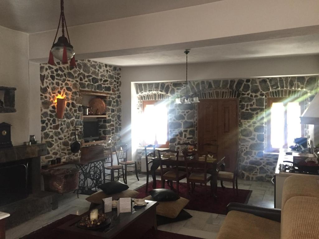 a living room with a table and a stone wall at Stephania's Stone House in Karyes