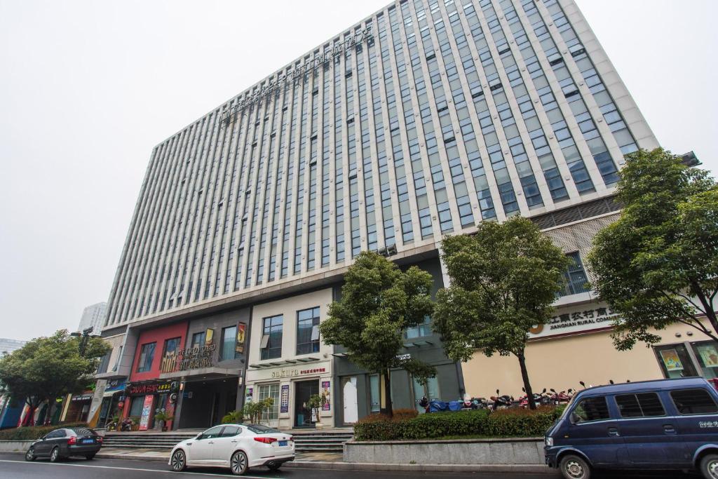 un gran edificio con coches estacionados frente a él en Metropolo, Changzhou, Changzhou Dinosaur Park New Taipei Wanda Plaza en Changzhou