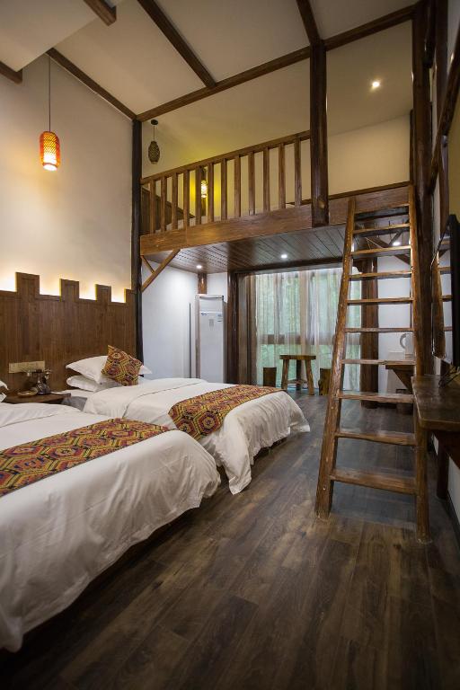 two beds in a room with a bunk bed at 张家界畔山驿栈 in Zhangjiajie